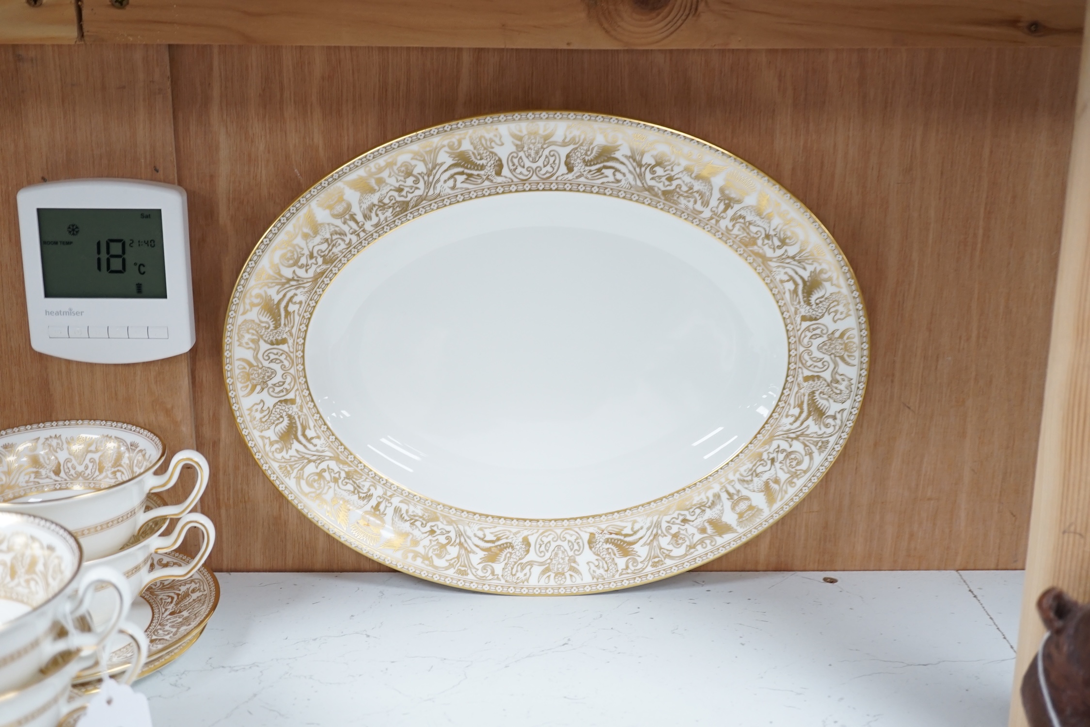 A Wedgwood bone china gold Florentine part dinner service, including an oval dish, twin handled cups and plates, largest 35cm wide